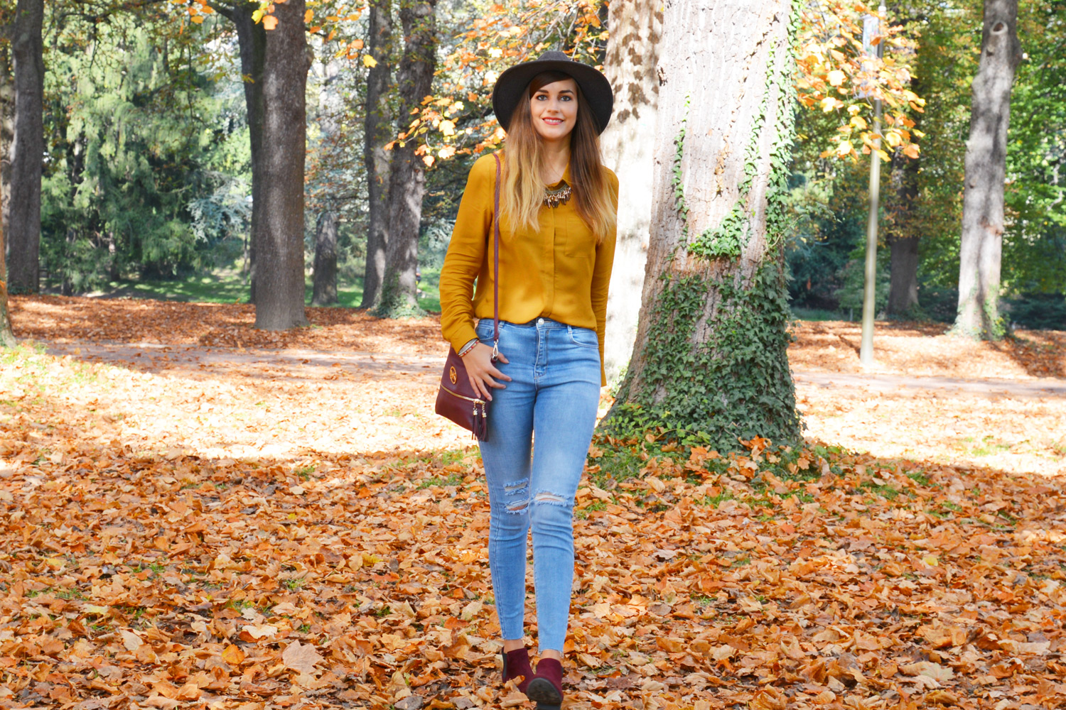 Look automne : chemise jaune moutarde, jean destroy, chapeau gris et boots bordeaux